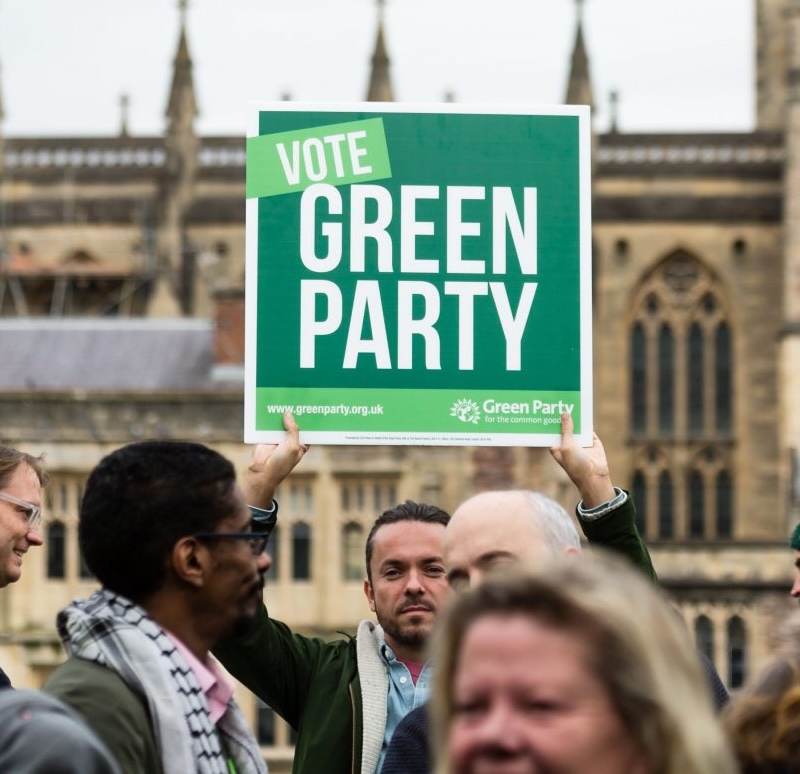 Seth Piper holding up a Vote Green Party placard